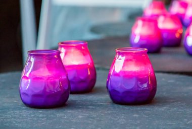 Hygge kavramı. Mor ve pembe mum masanın üzerine yazma