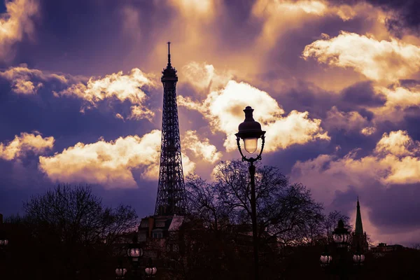 Evening Paris. Beautiful dramatic sky. Eiffel Tower and lantern on the evening sky background. Toned photo