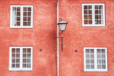 Pişmiş toprak duvar, sokak fener ve dört beyaz pencere