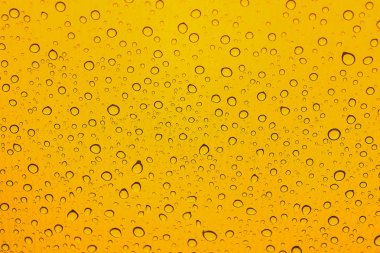 Araba camına yağmur damlaları. Sarı arka plan. Waterdrops desen