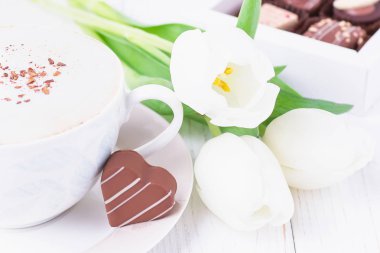 Seylan tarçın, çikolata kalp ve Beyaz Laleler üzerinde beyaz bir arka plan ile kahve kapuçino