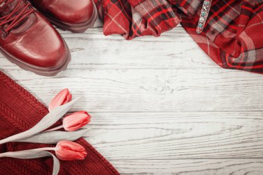 Çatı pişmiş toprak rengi. Şık ayakkabı, giyim ve bahar çiçek lale gri bir ahşap zemin üzerinde. Kopya alanı