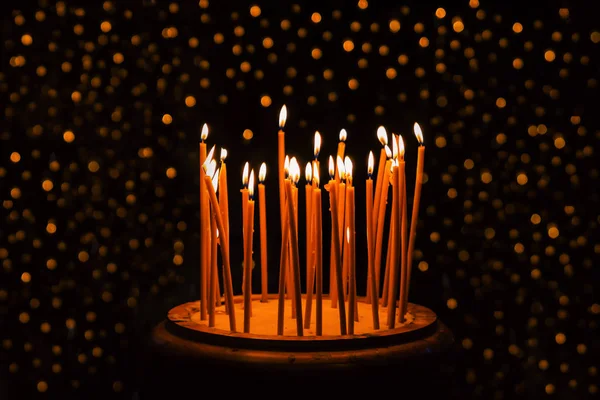 Dunne Gele Kaarsen Branden Donkere Achtergrond Met Glitter Lichten — Stockfoto