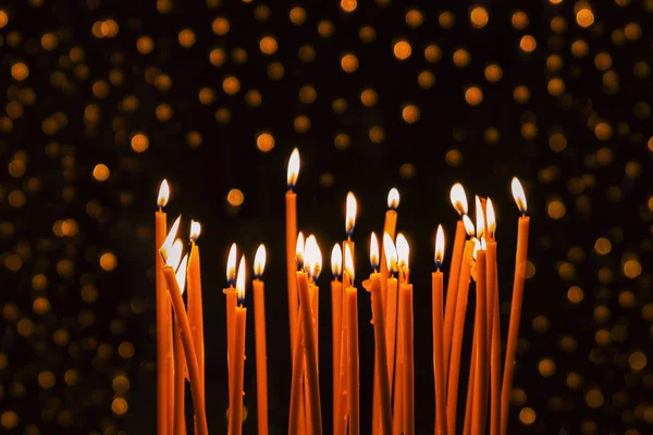 Velas Amarelas Finas Queimando Fundo Escuro Com Luzes Brilhantes — Fotografia de Stock