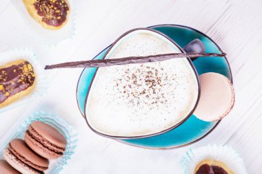 Fincan kahve vanilyalı kapuçino, Çikolata macaroons ve eklerleri