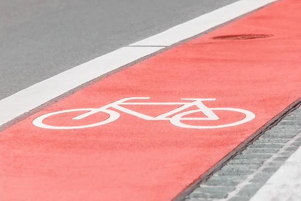 Piste cyclable avec un symbole de vélo sur la route asphaltée. Couleur corail tendance — Photo