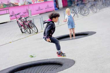 Berlin, Almanya. 18 Eylül 2016. Çocuk yakınında süpermarket sokakta bir trambolin üzerinde atlar. Eğleniyor