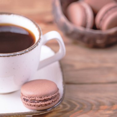 Beyaz siyah kahve ve tatlı çikolata macaroons ahşap arka plan üzerinde Fransız