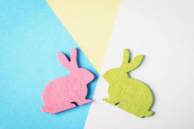 Mutlu paskalyalar. Mavi ve beyaz ve Sarı zemin üzerine pembe ve yeşil ahşap Paskalya tavşanı. Son moda yaratıcı fotoğraf. Kopya alanı