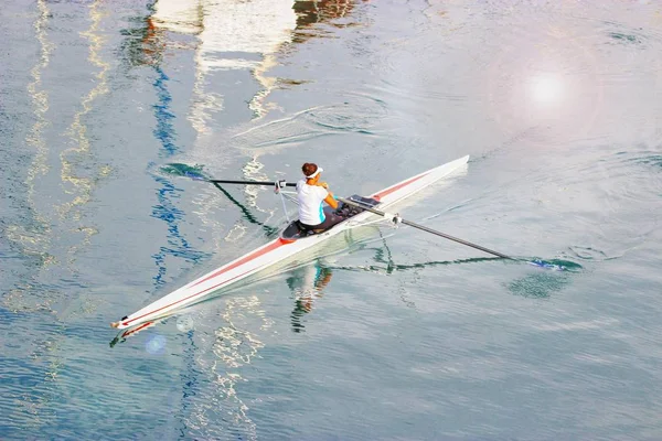Genç kadın bir kayık kürek çekmeye. Spor, aktif yaşam tarzı