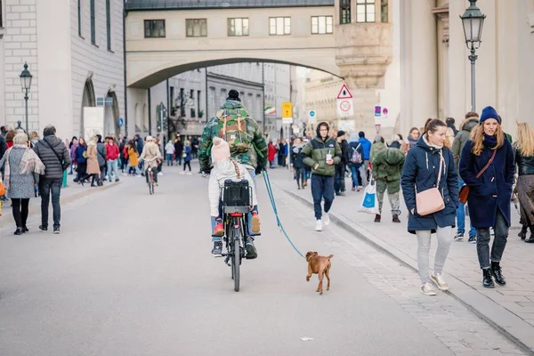 Monachium, Niemcy. 17 lutego 2019. Człowiek na rowerze z córką i pies — Zdjęcie stockowe
