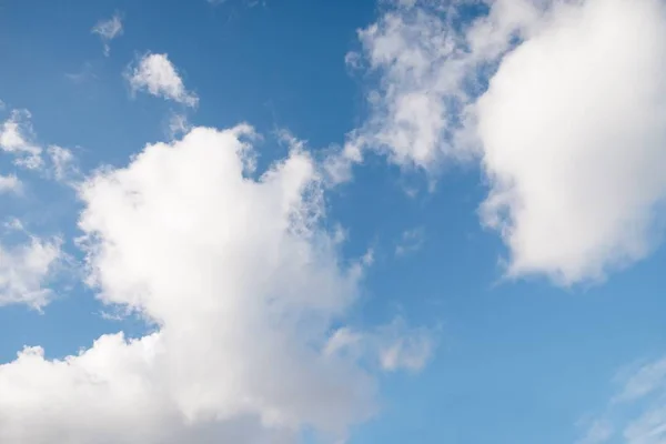 Красивые белые пушистые облака на голубом фоне неба — стоковое фото