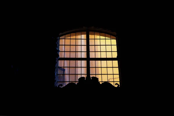 Ventana con luz amarilla sobre fondo negro. Copiar espacio — Foto de Stock