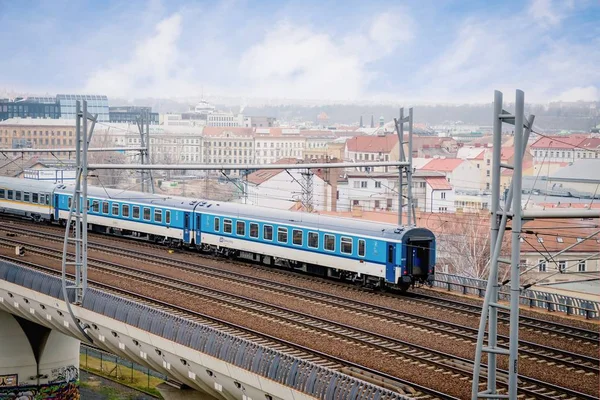 Praga, Repubblica Ceca. 2 marzo 2019. Il treno blu moderno passa attraverso il ponte. Vecchio sfondo della città — Foto Stock