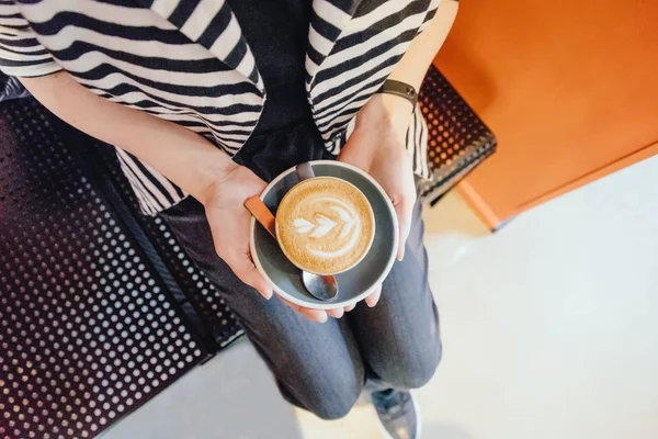 Female hands with a coffee cappuccino cup. Top view, copy space — Stock Photo, Image