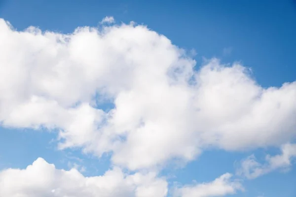 Белые пушистые облака на голубом фоне неба — стоковое фото