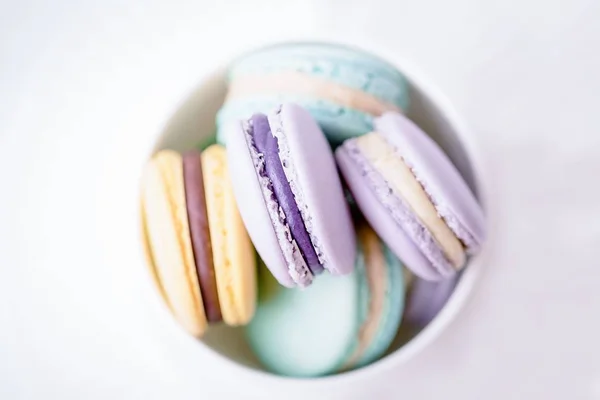 Macarons français pastel doux et colorés ou macaron sur fond blanc. Vue du dessus, espace de copie — Photo