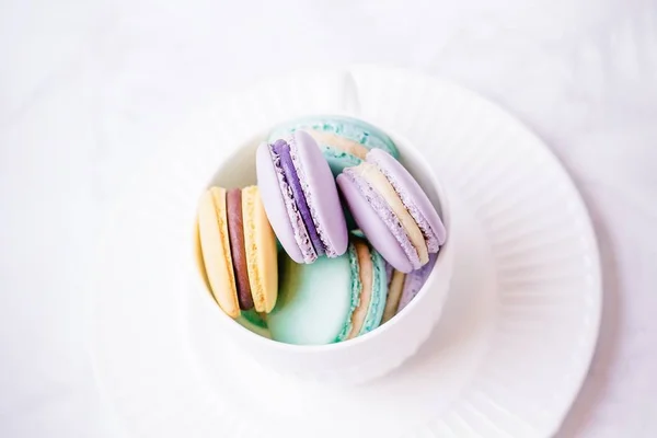 Dolci macaron francesi colorati o macaron su fondo di marmo bianco. Vista dall'alto, copia spazio — Foto Stock