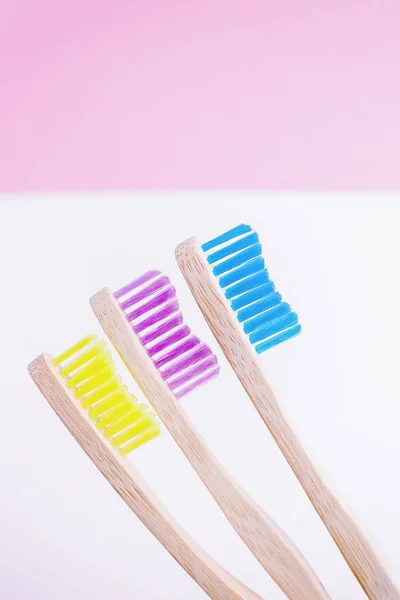 Yellow, pink and blue bamboo toothbrushes. Eco-friendly concept. Minimal, pink background. Copy space — Stock Photo, Image