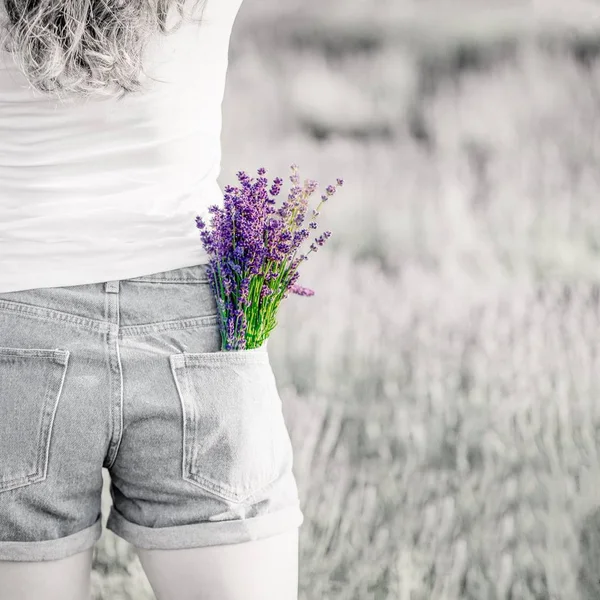 Strauß lila Lavendelblüten in der Jeanstasche. Schwarz-Weiß-Foto, heller Strauß. Kopierraum — Stockfoto