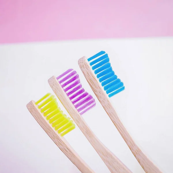 Yellow, pink and blue bamboo toothbrushes. Eco-friendly concept. Minimal, white background. Copy space — Stock Photo, Image