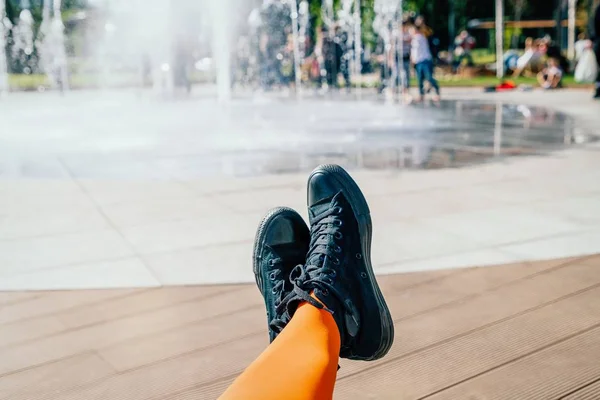 Patas femeninas con elegantes medias naranjas y zapatillas negras sobre fondo de fuente — Foto de Stock