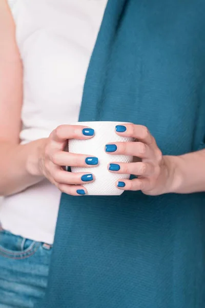 Vackra kvinnliga händer håller vit kopp. Manikyr med blå turkos nagellack — Stockfoto
