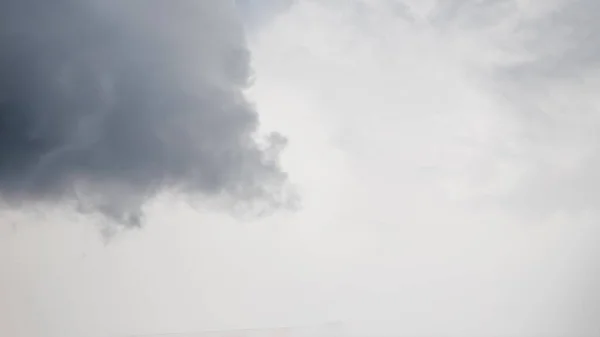 One dark gray cloud on the pale grey sky panorama background