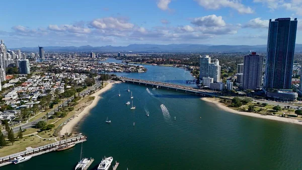 Altın Sahil, Queensland, Avustralya 'nın bu insansız hava aracı görüntüsü çarpıcı şehir silueti, yüksek kuleler, altın plajlar ve ikonik Sörfçüler Cenneti' ni içeriyor. Fotoğraf, deniz kenarındaki ışıl ışıl kanalları, lüks marinaları ve yol alan tekneleri yakalıyor. 