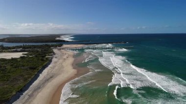 4K hava aracı görüntüleri Wave Break Adası, altın kumlu plajlar, dar kumlu şeritler, sahil rezervi, Gold Coast Seaway, nehirde yelkenli tekneleri ve Pasifik Okyanusu kıyılarını gösteriyor. Bu popüler Queensland plajları ile ünlüdür.