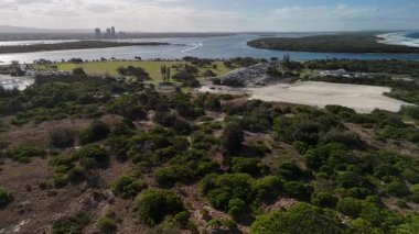 4K hava aracı görüntüleri Wave Break Adası, altın kumlu plajlar, dar kumlu şeritler, sahil rezervi, Gold Coast Seaway, nehirde yelkenli tekneleri ve Pasifik Okyanusu kıyılarını gösteriyor. Bu popüler Queensland plajları ile ünlüdür.