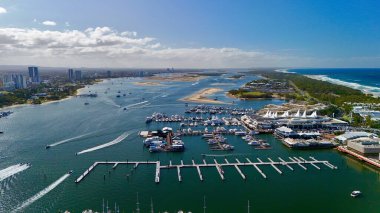 Altın Sahil, Queensland, Avustralya 'nın bu insansız hava aracı görüntüsü çarpıcı şehir silueti, yüksek kuleler, altın plajlar ve ikonik Sörfçüler Cenneti' ni içeriyor. Fotoğraf, deniz kenarındaki ışıl ışıl kanalları, lüks marinaları ve yol alan tekneleri yakalıyor.