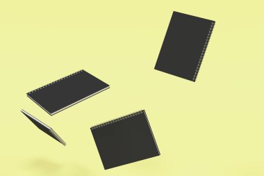 Dört boş defter ile siyah kapakları ve metal sarmal sarı arka plan üzerinde bağlı. İş veya eğitim mockup. 3D render illüstrasyon