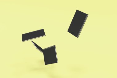 Dört boş defter ile siyah kapakları ve metal sarmal sarı arka plan üzerinde bağlı. İş veya eğitim mockup. 3D render illüstrasyon