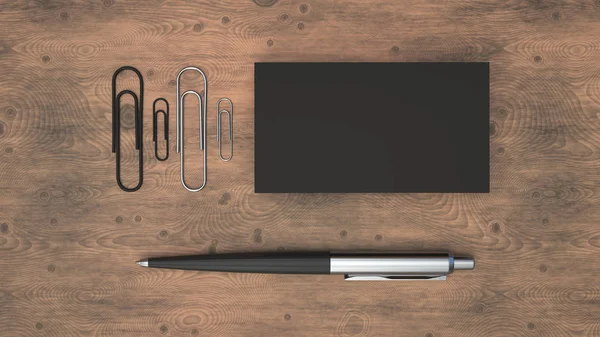 Black business cards, paper clips and automatic ballpoint pen on wooden table. Blank paper mockup. 3D rendering illustration.