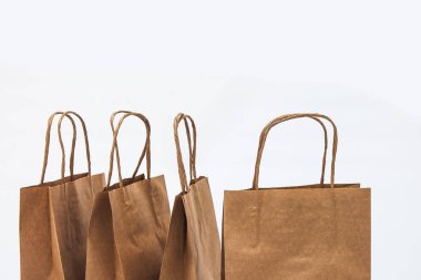 Kraft torba üst üste - beyaz bir arka plan üzerinde Satılık, alışveriş ve hediyeler