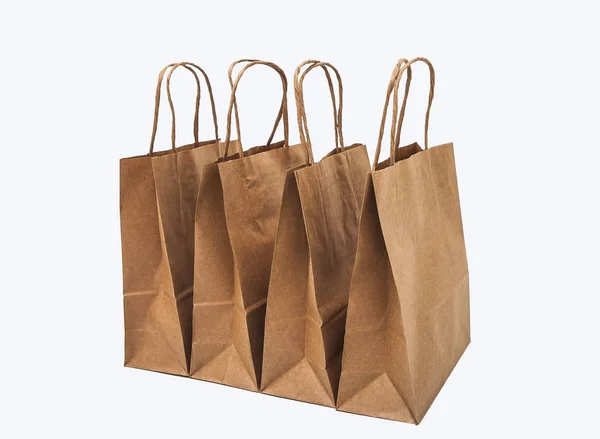 ショッピング ギフト 行の白い背景の上のクラフト袋 — ストック写真