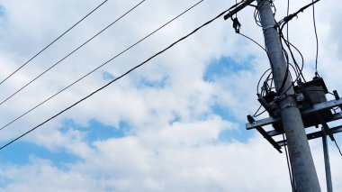 Mavi gökyüzü, bulutlar ve elektrik direklerinin manzarası