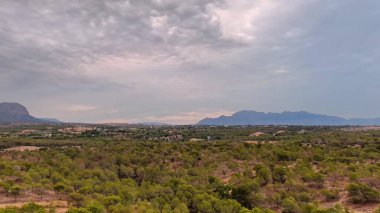 İnanılmaz derecede çarpıcı bir gökyüzü altında canlı yeşilliklerle kaplanmış görkemli dağların nefes kesici manzarası.