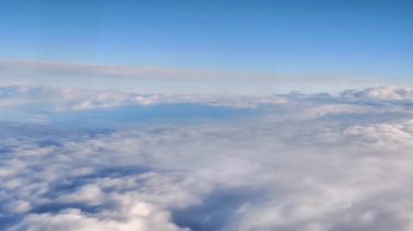 Tüylü bulutların nefes kesici panoramik görüntüsünü deneyimleyin yukarıdan canlı mavi bir gökyüzünün altında güzelce düzenlenmiştir.