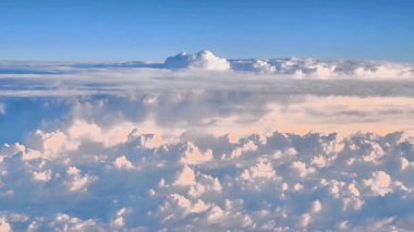 Bu hava görüntüsü parlak mavi gökyüzü altında tüylü bulutları gösteriyor, sunumlar ve yaratıcı projeler için ideal.