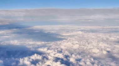 Pofuduk bulutlar ve açık mavi gökyüzü, doğa ve seyahat temaları için mükemmel..