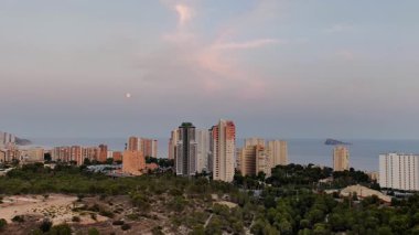 Modern binaların nefes kesen manzarası muhteşem bir şekilde sakin denizin altında, alacakaranlık altında.