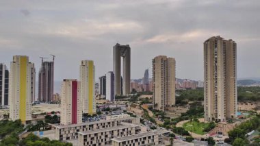 Canlı şehir ortamındaki yemyeşil alanların yanındaki modern gökdelenlerin nefes kesici manzarasının tadını çıkarın.