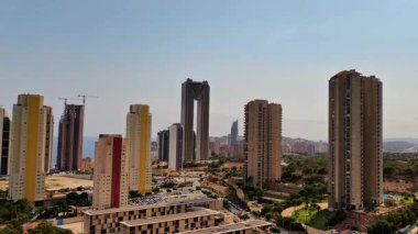 Çarpıcı bir gökyüzü altında modern mimari, etkileyici binalar ve yeşillikleri barındırır.