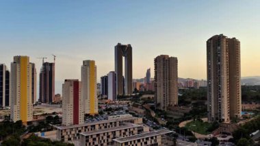 Alacakaranlık sırasında kentsel gelişimi vurgulayan çağdaş gökdelenleri gösteren nefes kesici bir panoramik manzara