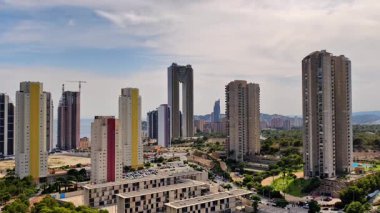 Canlı bir şehir manzarası çağdaş gökdelenler, çeşitli konut binaları ve bereketli şehir yeşilliği.