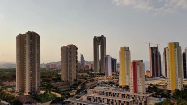 Hava kararırken gökdelenlerin ve konut binalarının yer aldığı çağdaş bir şehrin çarpıcı manzarası..