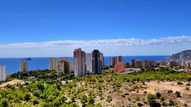 Nefes kesen sakin Akdeniz 'e karşı ikonik Benidorm siluetini gösteren çarpıcı bir panoramik manzara