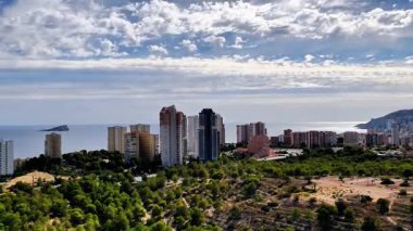 Etkileyici bir hava görüntüsü güzel bir şekilde canlı bir sahil kenti, çarpıcı bir yeşillik ve inanılmaz bir deniz manzarası sergiliyor.